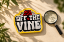 A yellow Off The Vine pouch beside a magnifying glass on a cream surface with leafy shadows.