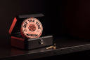 A strawberry Off The Vine gummy tin standing in an open black lockbox on a dark shelf, a brass key beside it, lit with a red rim light.